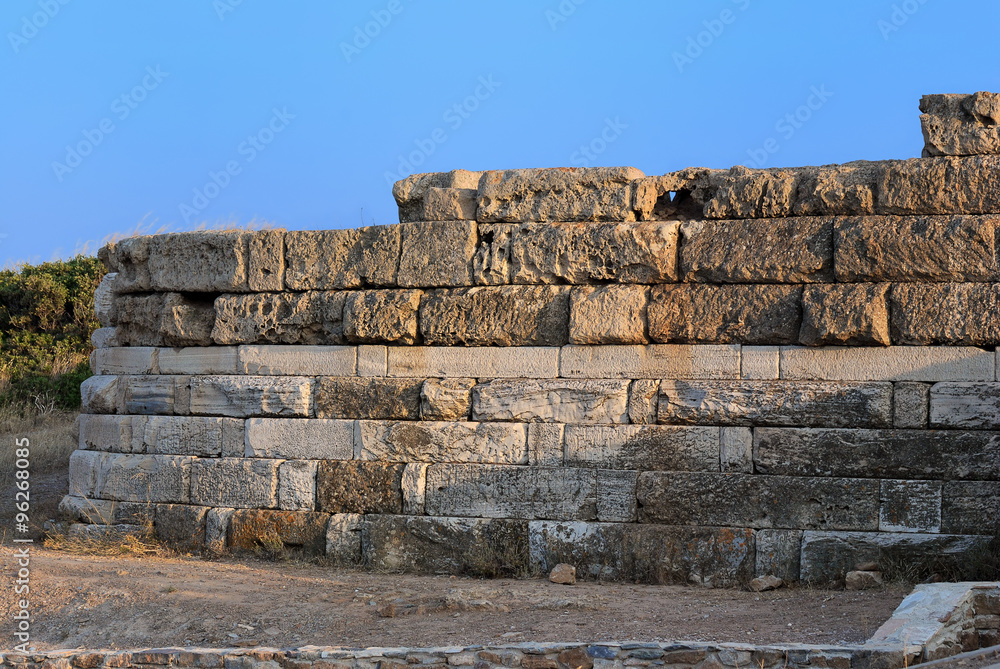 A fragment of the old walls of the ancient Temple of Poseidon at Cape Sounion in the warm summer evening. Greece.