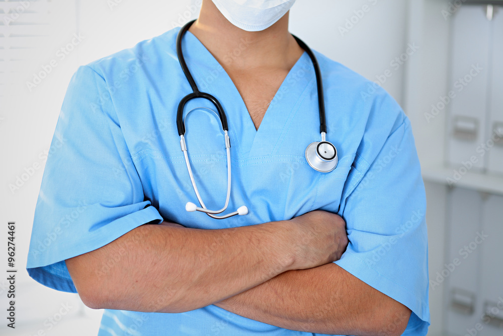 Portrait of unknown male surgeon doctor holding his stethoscope, crossed arms Portrait of unknown male surgeon doctor holding his stethoscope, crossed arms