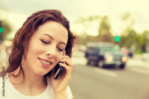 Portrait of a young woman talking on mobile phone outdoors