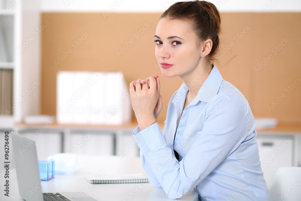 Young business woman working on laptop in office. Successful business concept. Young business woman working on laptop in office. Successful business concept.