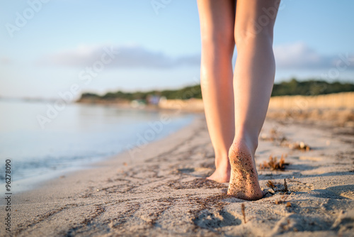 Woman walking on the beach at sunrise enjoying her leisure, Piantarella beach, Corsica France