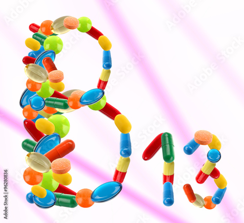 B 13 made of different pills on colour background