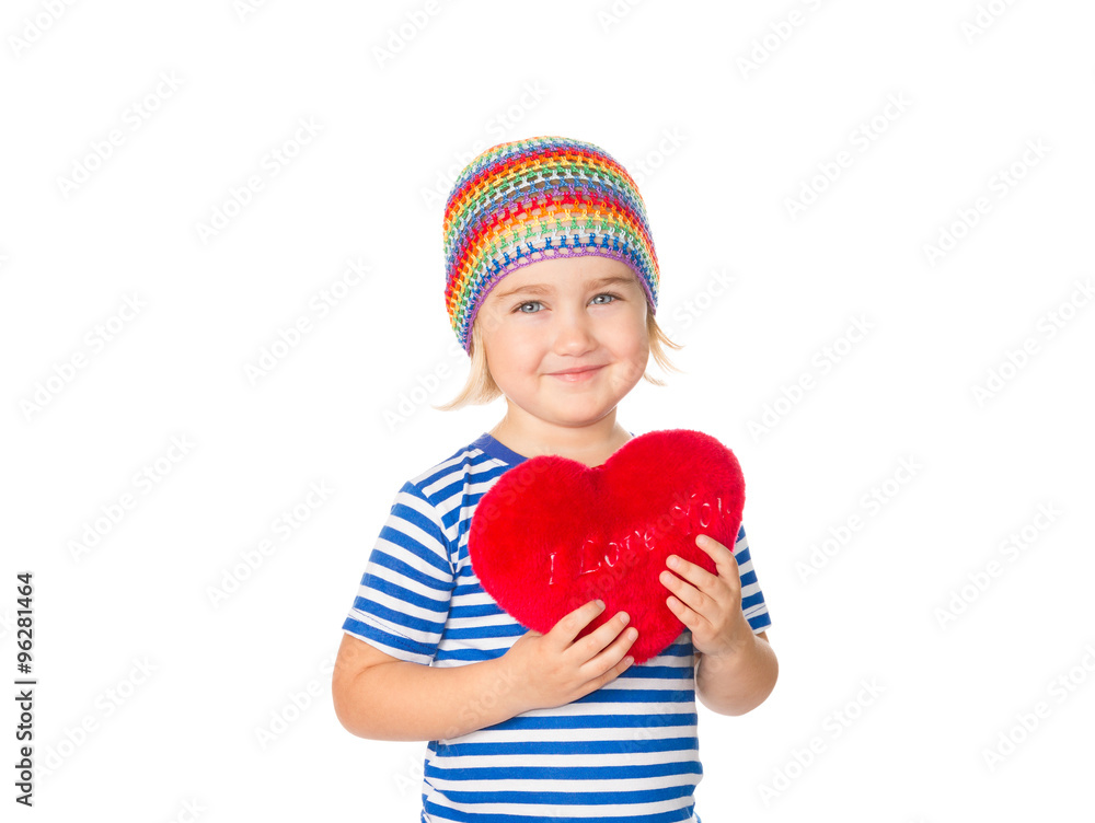 Little girl holding a red heart toy.