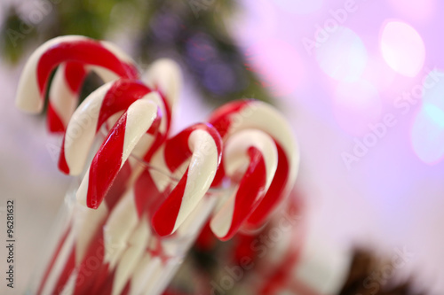 Christmas Candy Canes in glass on table on light background