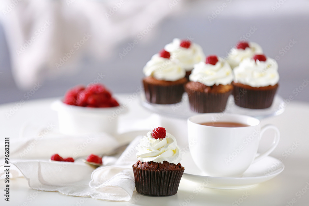 Beautiful chocolate cupcakes and cup of tea, on table Beautiful chocolate cupcakes and cup of tea, on table