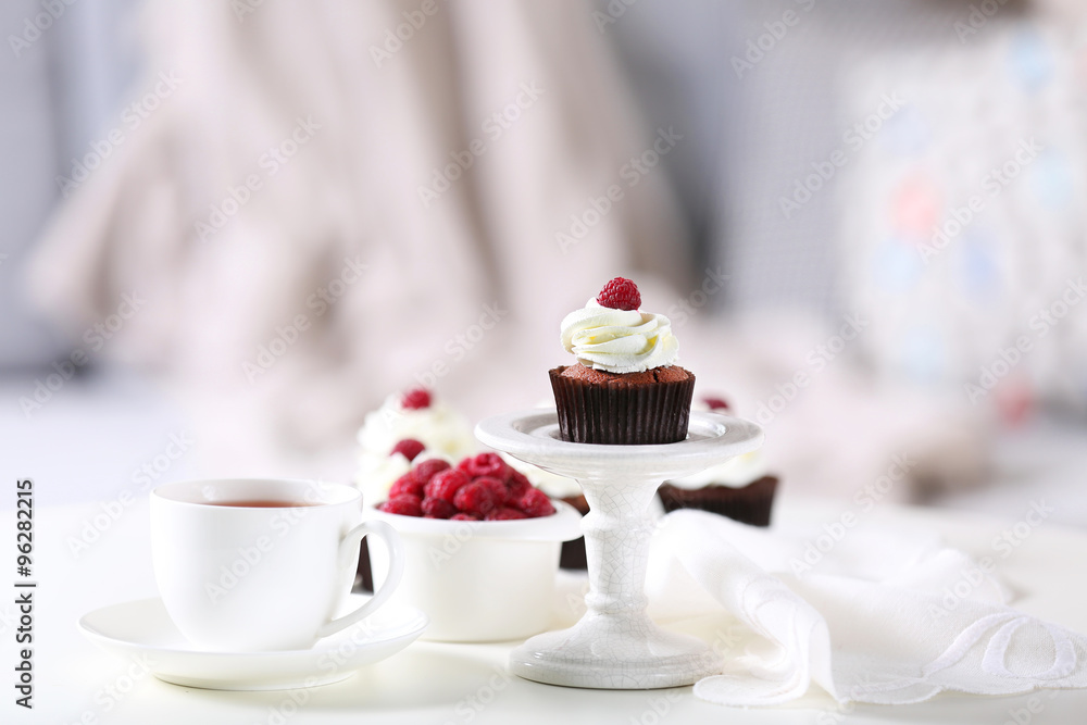 Beautiful chocolate cupcakes with cream and raspberry on table Beautiful chocolate cupcakes with cream and raspberry on table