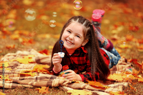 Cute girl lying on plaid an...