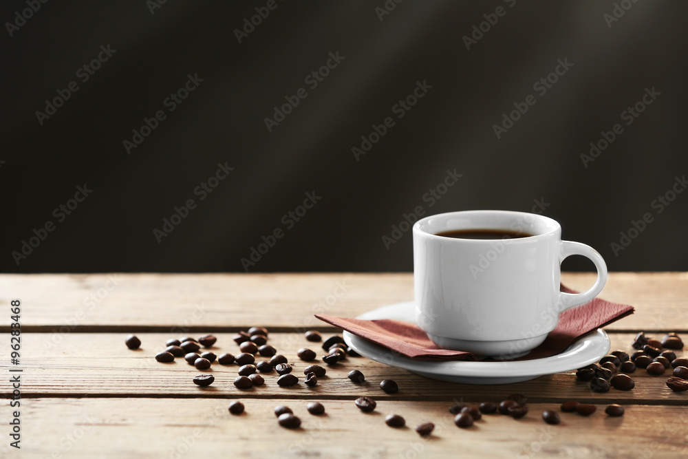 Cup of coffee and coffee grains on wooden table, on gray background Cup of coffee and coffee grains on wooden table, on gray background