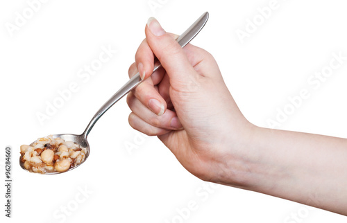 hand holding spoon with beans soup isolated
