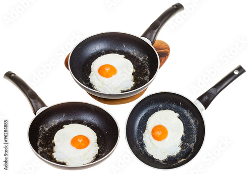 set of frypans with one fried egg isolated photo