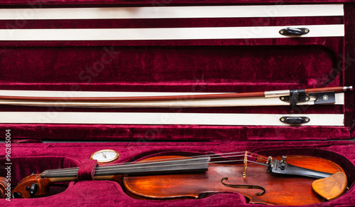 old violin with bow in red velvet case
