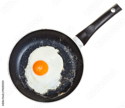 top view of one fried egg in black frypan isolated