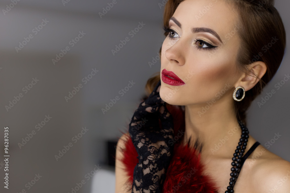 Obraz premium beautiful sexy young woman flaunts front of the mirror in the dressing room in lacy underwear in a retro style with bright make-up and beautiful evening hairstyles , shot in the style of the 20s