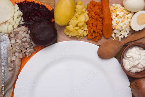 Ingredients for the herring salad with an empty plate photo