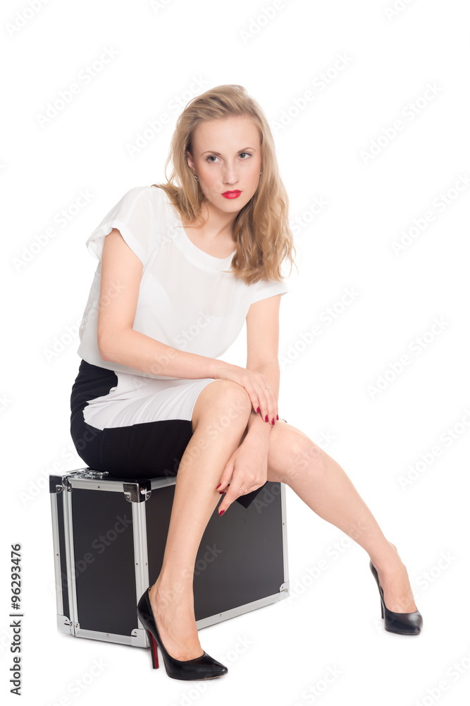 Young woman sitting on a suitcase Young woman sitting on a suitcase
