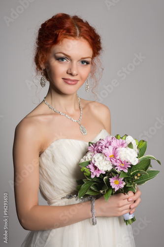 Happy bride with red hair on gray