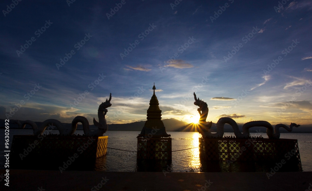 Silhouettes dragon and Naga statue on sunset