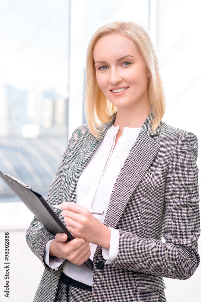 Confident businesswoman holding folder Confident businesswoman holding folder