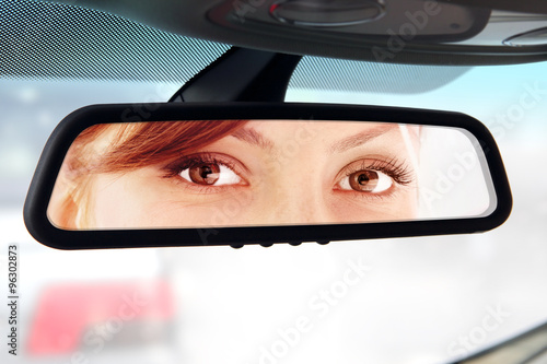 woman looks to rear-view mirror