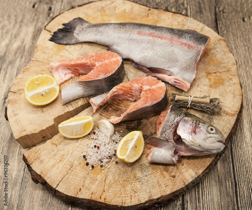 Fresh Norwegian rainbow trout steaks with lemon lies on a wooden background