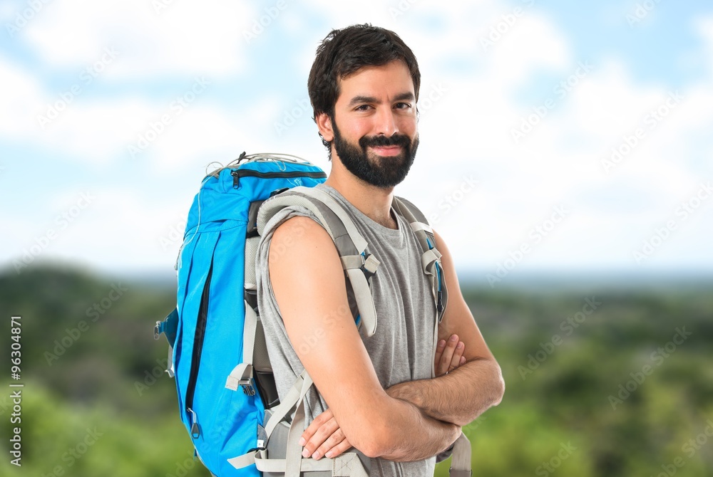 Naklejka premium Backpacker with his arms crossed over white background