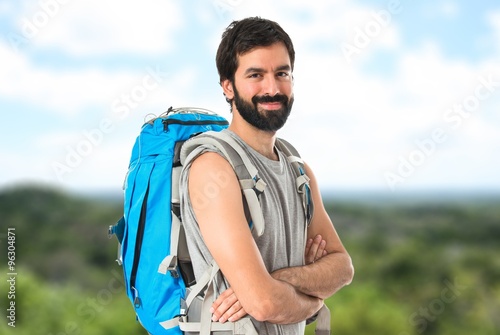 Backpacker with his arms crossed over white background