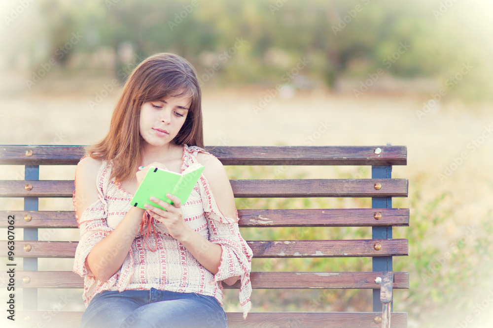 woman reading a book sitting on the bench woman reading a book sitting on the bench