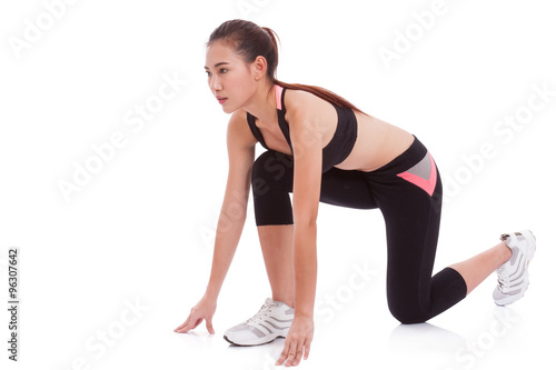 Sport woman in position to start running on white background
