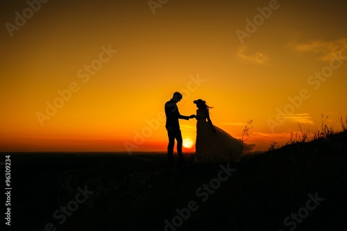 silhouette of couple with sunset background