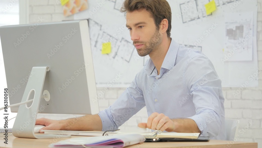 Architect working in office, writing on agenda Architect working in office, writing on agenda