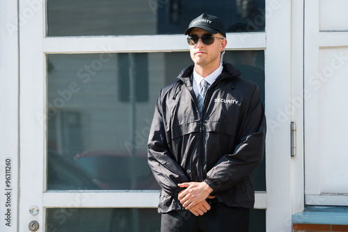 Fotografia Męski pracownik ochrony stoi przy wejściem