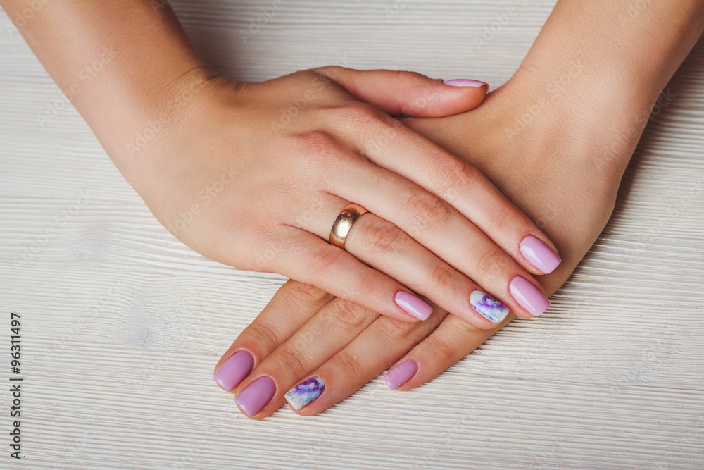 Lilac nail art with printed flowers on light background Lilac nail art with printed flowers on light background