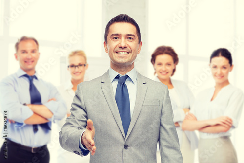 happy smiling businessman in suit shaking hand