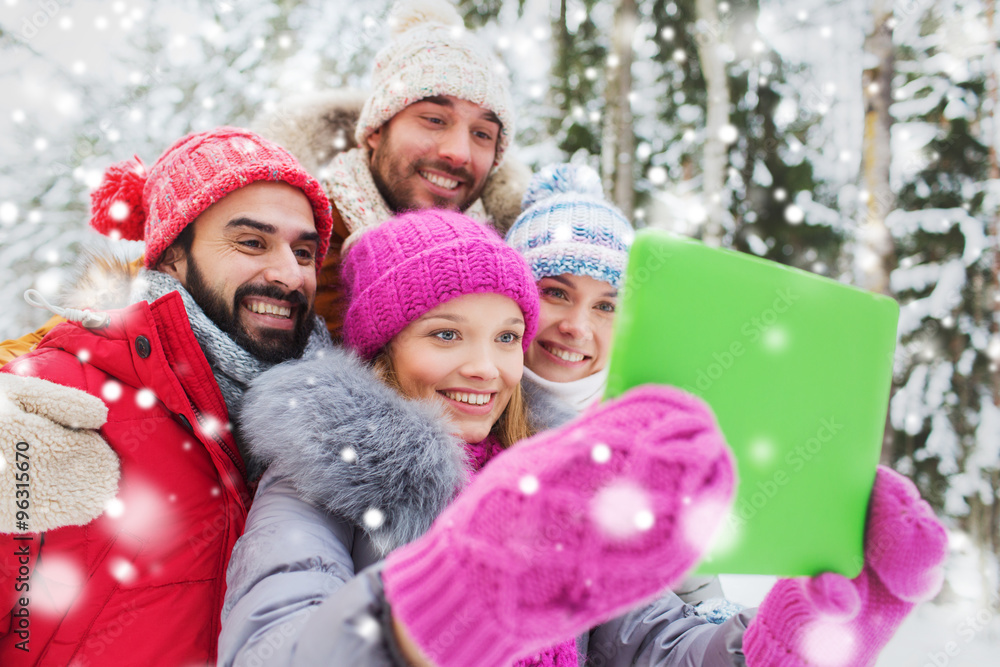 smiling friends with tablet pc in winter forest smiling friends with tablet pc in winter forest