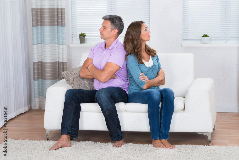 Unhappy Couple Sitting On Sofa Unhappy Couple Sitting On Sofa