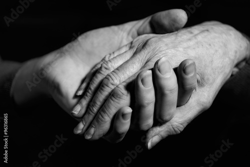 Monochrome Shot Of Young Woman Holding Older Woman's Hand