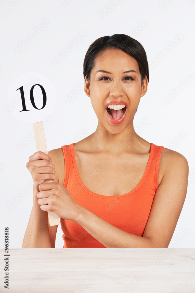 Happy Woman Holding Up Scorecard Giving Mark Out Of Ten Happy Woman Holding Up Scorecard Giving Mark Out Of Ten