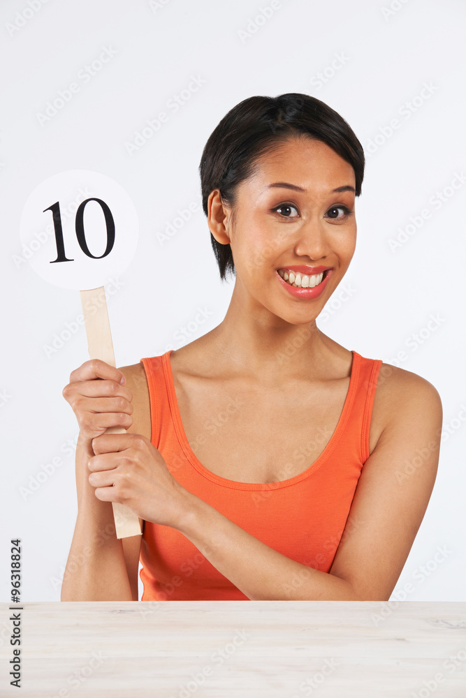 Happy Woman Holding Up Scorecard Giving Mark Out Of Ten Happy Woman Holding Up Scorecard Giving Mark Out Of Ten