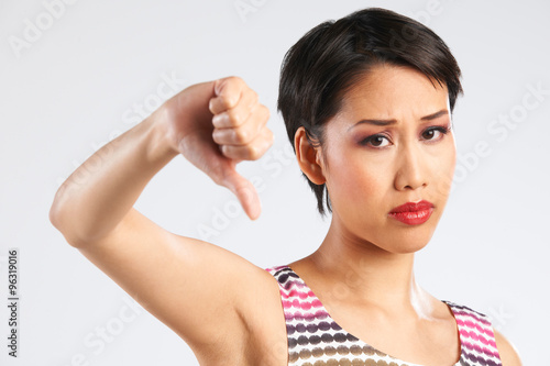 Studio Shot Of Woman Giving Thumbs Down Gesture