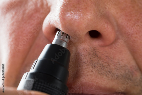 Man Removing Hair From His Nose With Trimmer