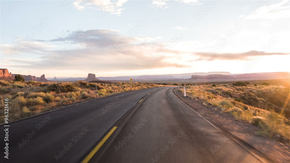 Driving USA: Sunset sunrise point of view shot along empty desert highway through Monument Valley, Arizona Utah