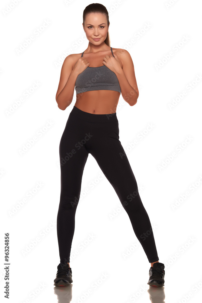 Fitness woman in sport style standing against isolated white background Fitness woman in sport style standing against isolated white background