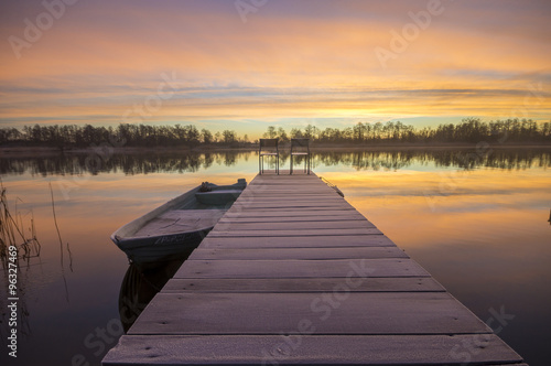 Fototapeta Naklejka Na Ścianę i Meble -  łódka zacumowana zimą do drewnianego pomostu
