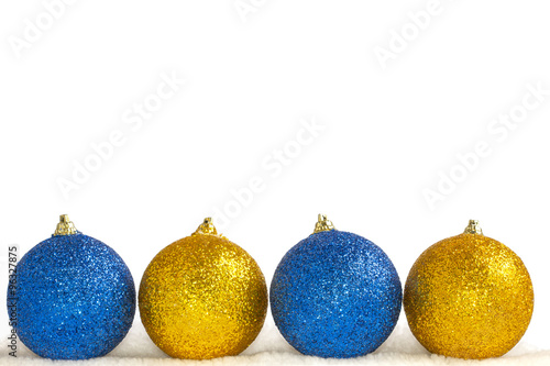Christmas decorations on a white background. Four balls on artificial snow