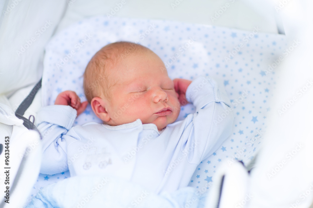 Newborn baby boy sleeping in white pram