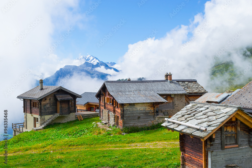 Belalp village in fog. Wooden houses and buildings in old style, vintage.