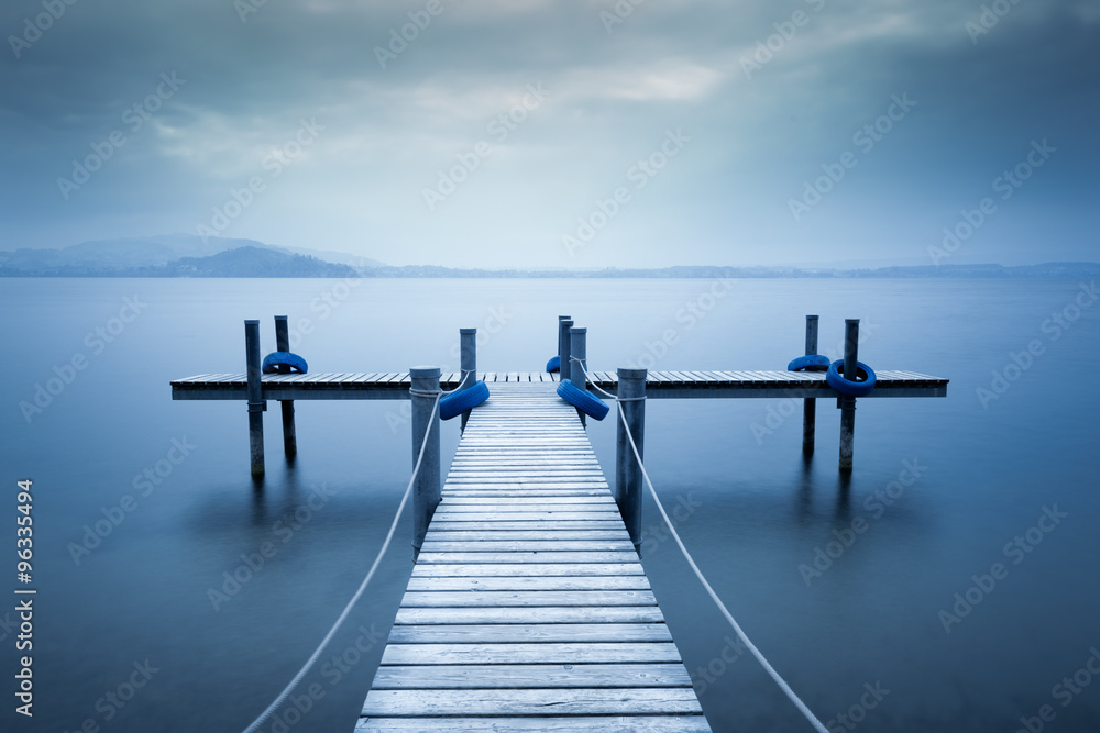 Lake Zug. Wooden pier on the lake. Fog. Long exposure. 