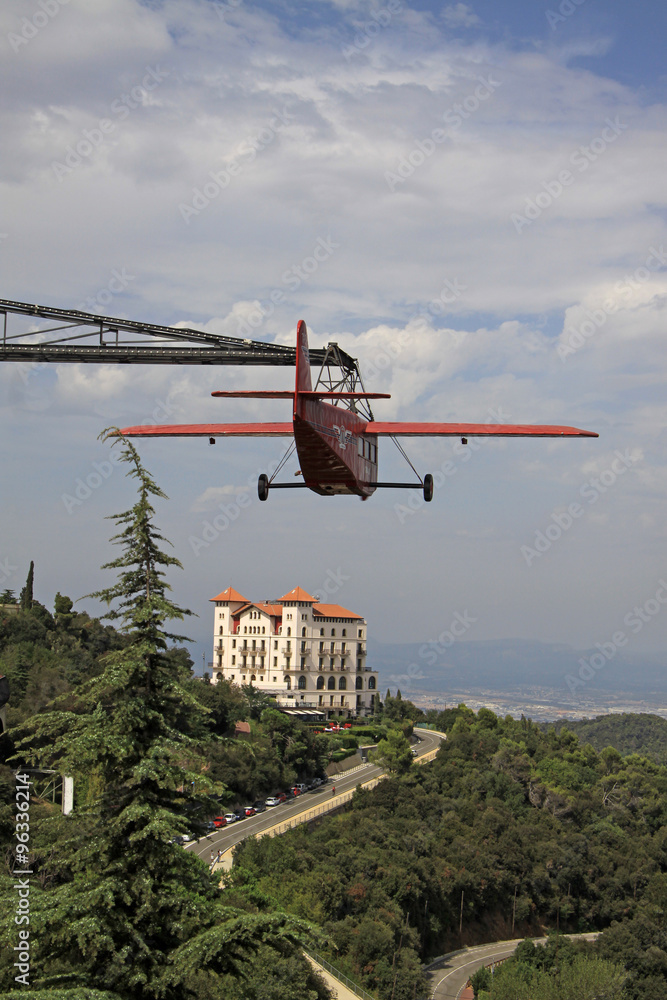 Fototapeta premium BARCELONA, CATALONIA, SPAIN - AUGUST 29, 2012: Red aeroplane and Gran Hotel La Florida near Tibidabo, Barcelona,Catalonia, Spain
