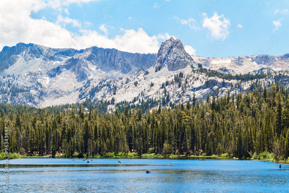 Shallow quiet Mammoth Lake among the mountains and pine forest, California, USA