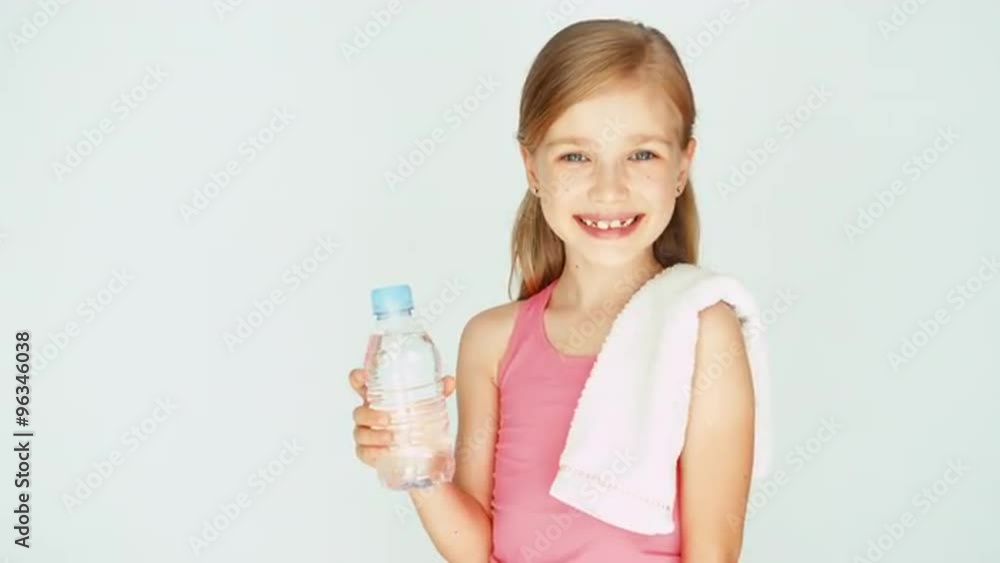 Portrait sportswoman girl child showing bottle of water. Thumb up. Ok Portrait sportswoman girl child showing bottle of water. Thumb up. Ok